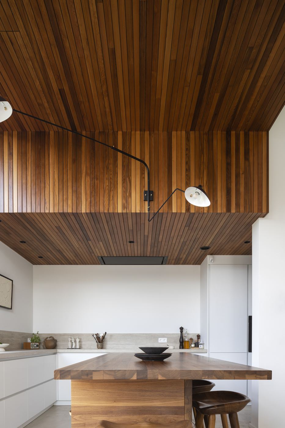 Cuisine avec plafond en lattes de bois et îlot en noyer