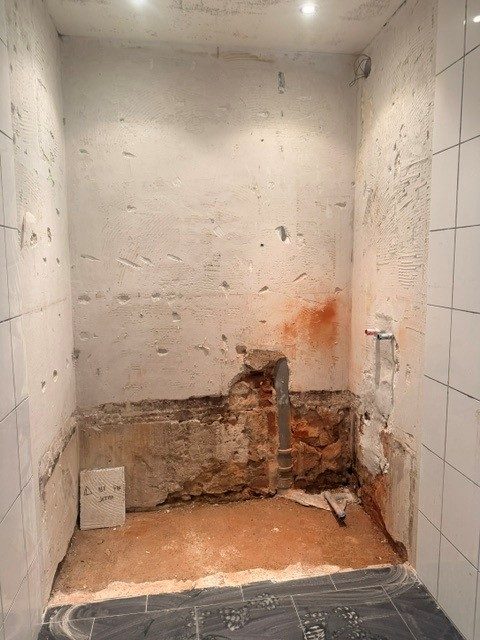 Salle de douche de la conciergerie démolie jusqu'au mur brut