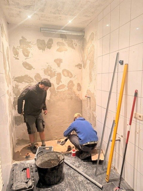 Deux ouvriers préparant la pose du receveur de douche