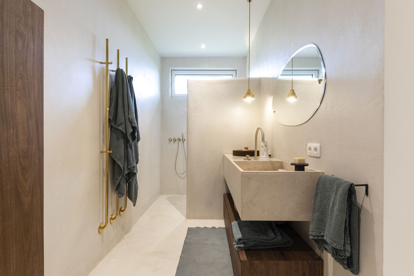 Salle de bain en enduit minéral avec vasque en pierre et douche à l'italienne